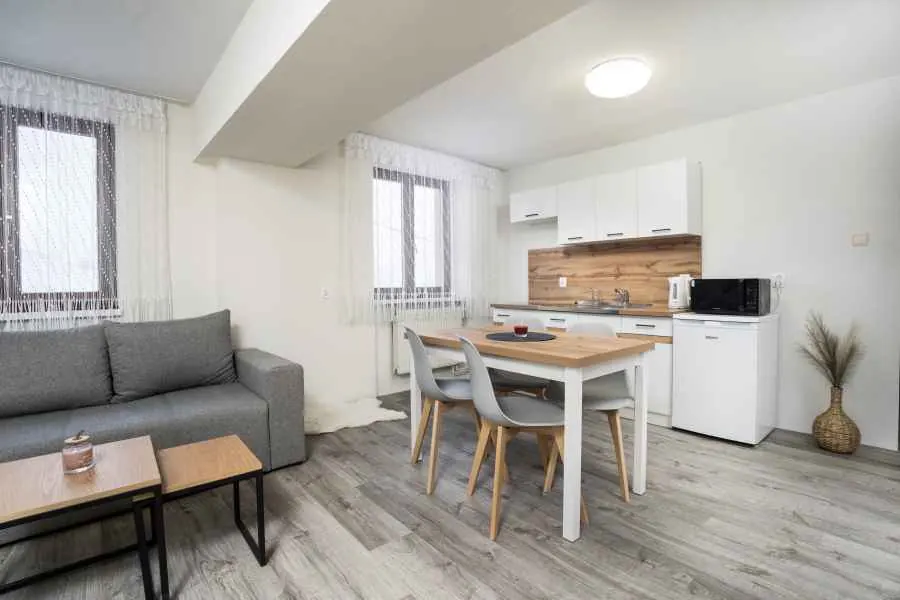 Kuchyňa s jedálenským stolom a sedačkou v apartmáne č. 1