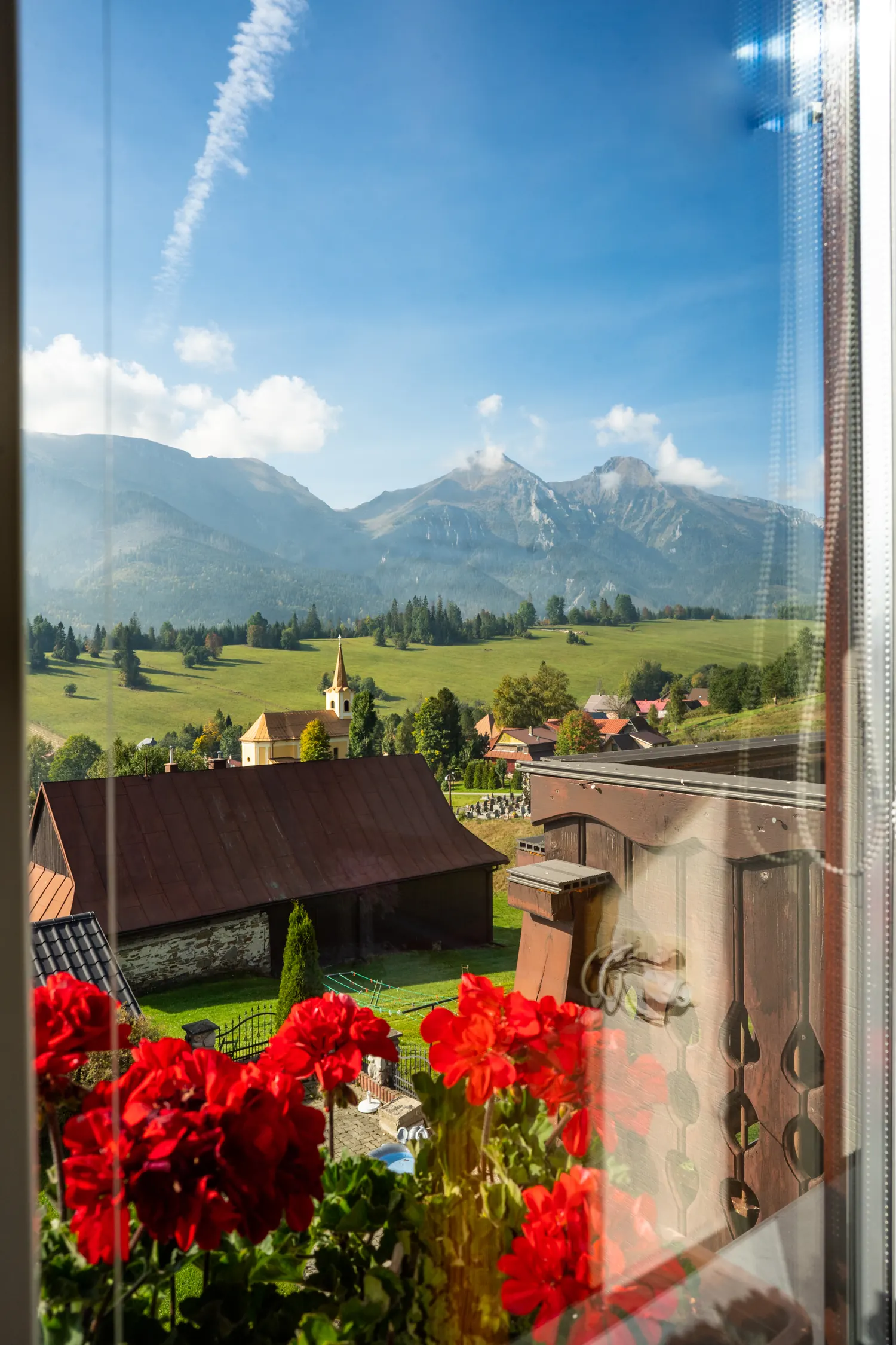 Letný výhľad z okna apartmánu č. 1 cez muškáty na Ždiar a Belianske Tatry