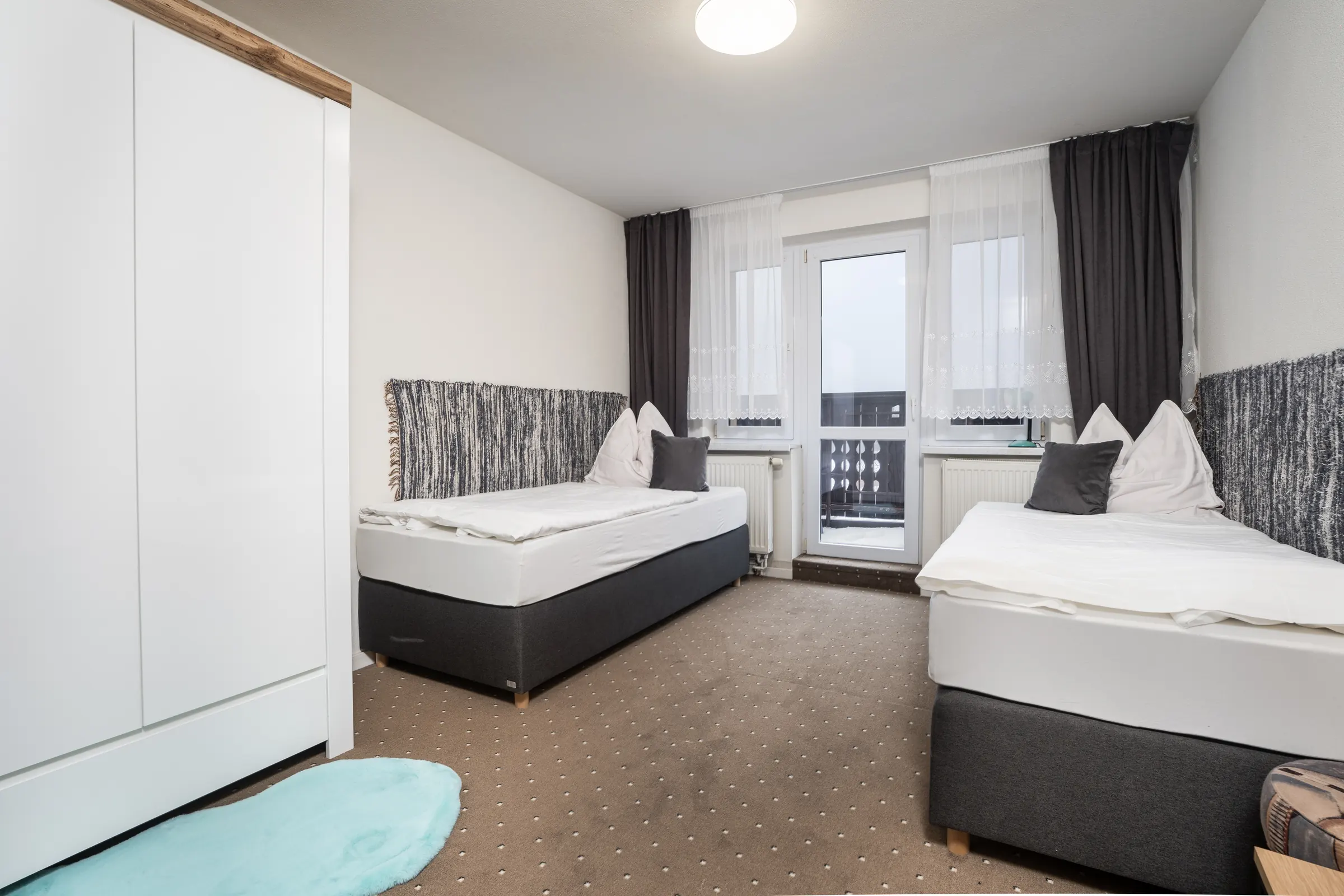 Spálňa č. 1 v apartmáne č. 2: dve samostatné postele a dvere na balkón