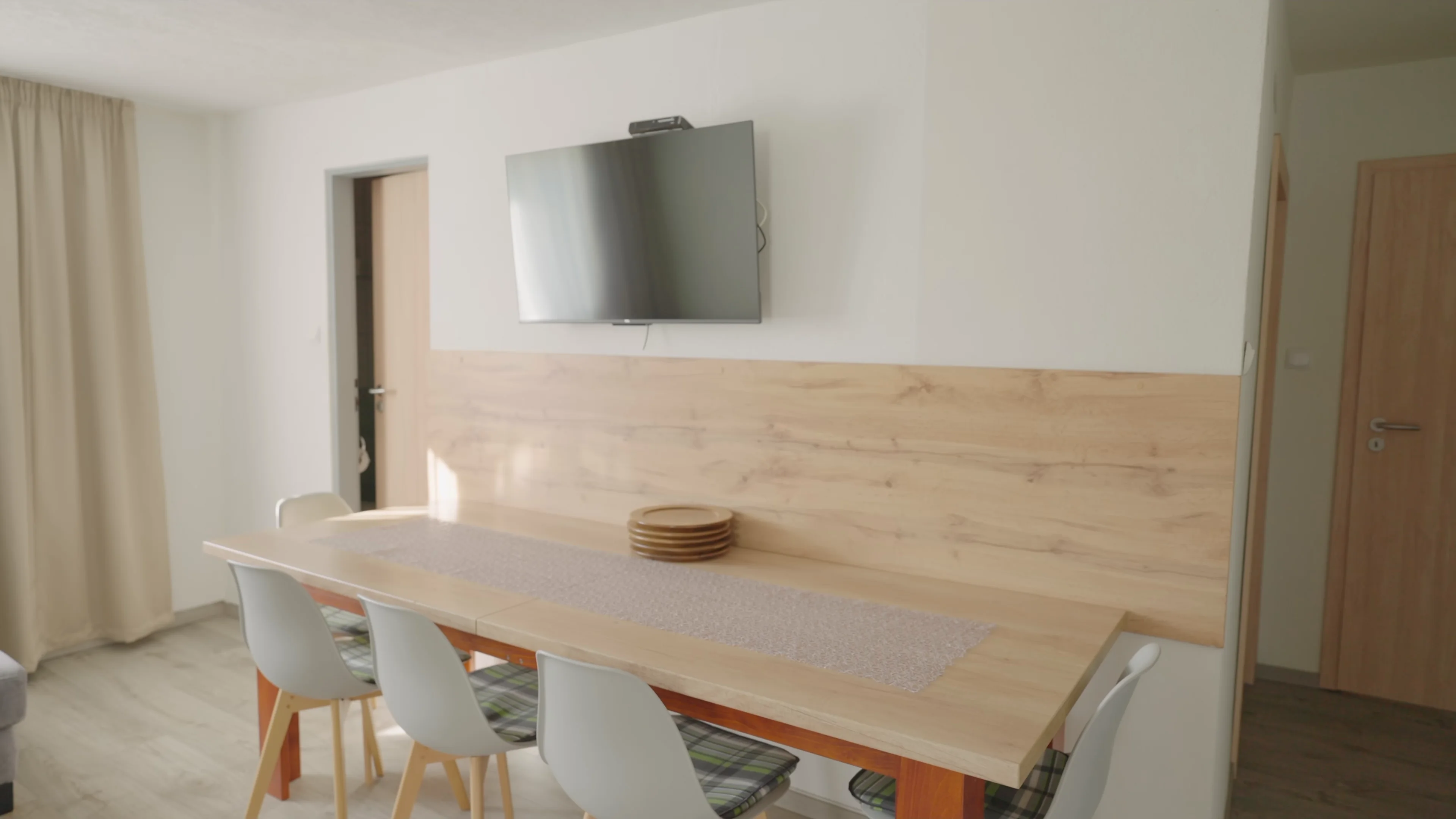 Jedálenský stôl v apartmáne s dreveným obkladom steny