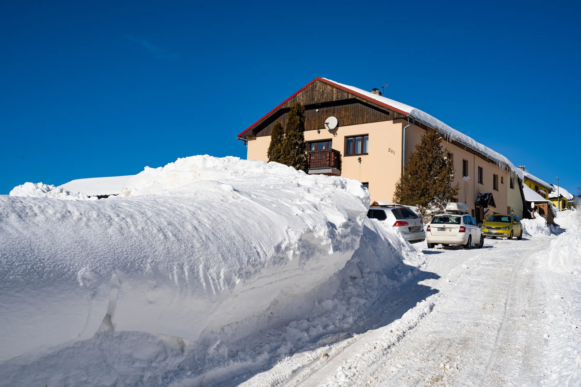 House No. 281 in Ždiar in winter, seen from the street below with a snowdrift