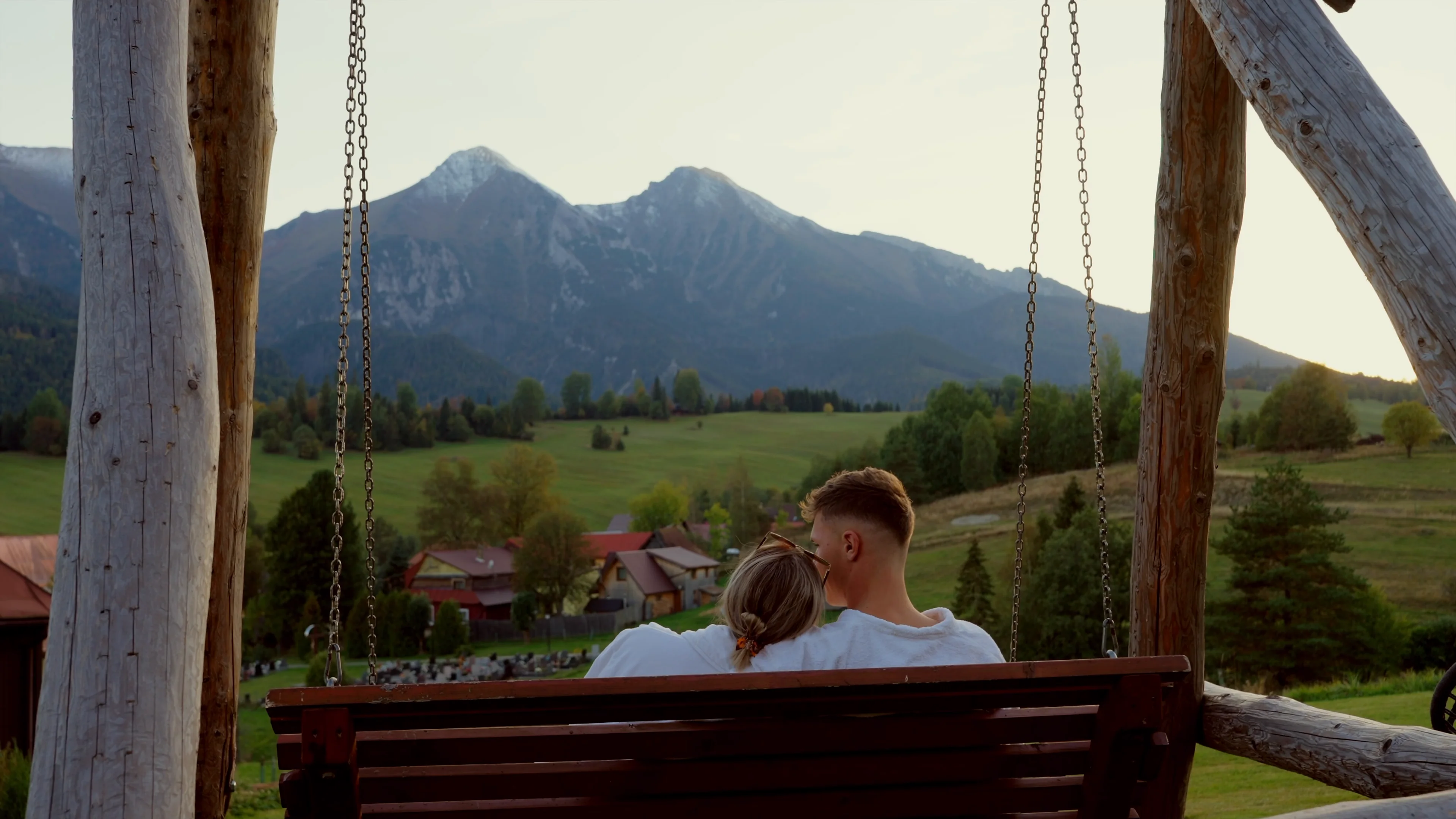 Dvojica na hojdačke na terase, v pozadí Belianske Tatry