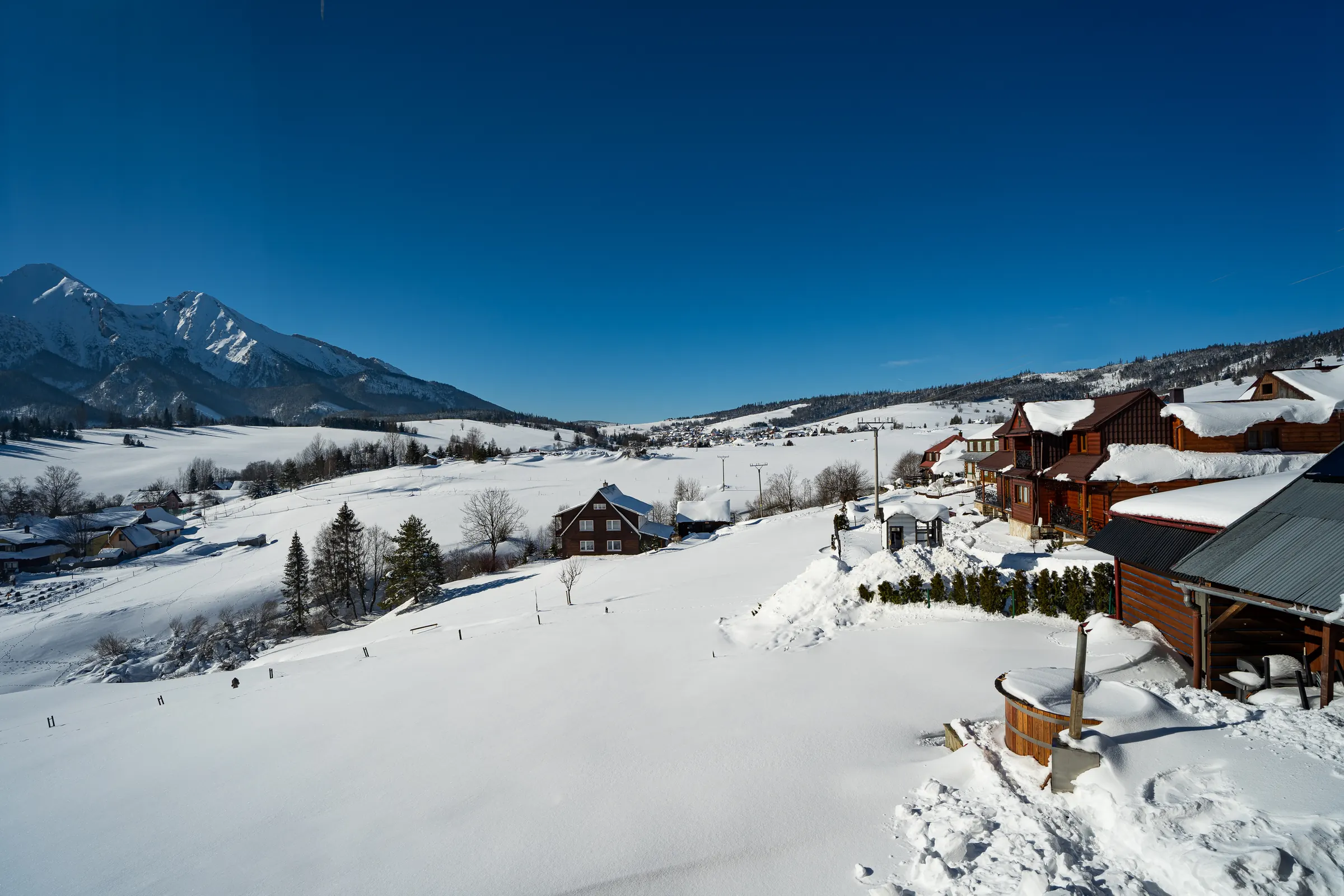 Zimný výhľad z okna obývačky na zasnežené lúky a Belianske Tatry