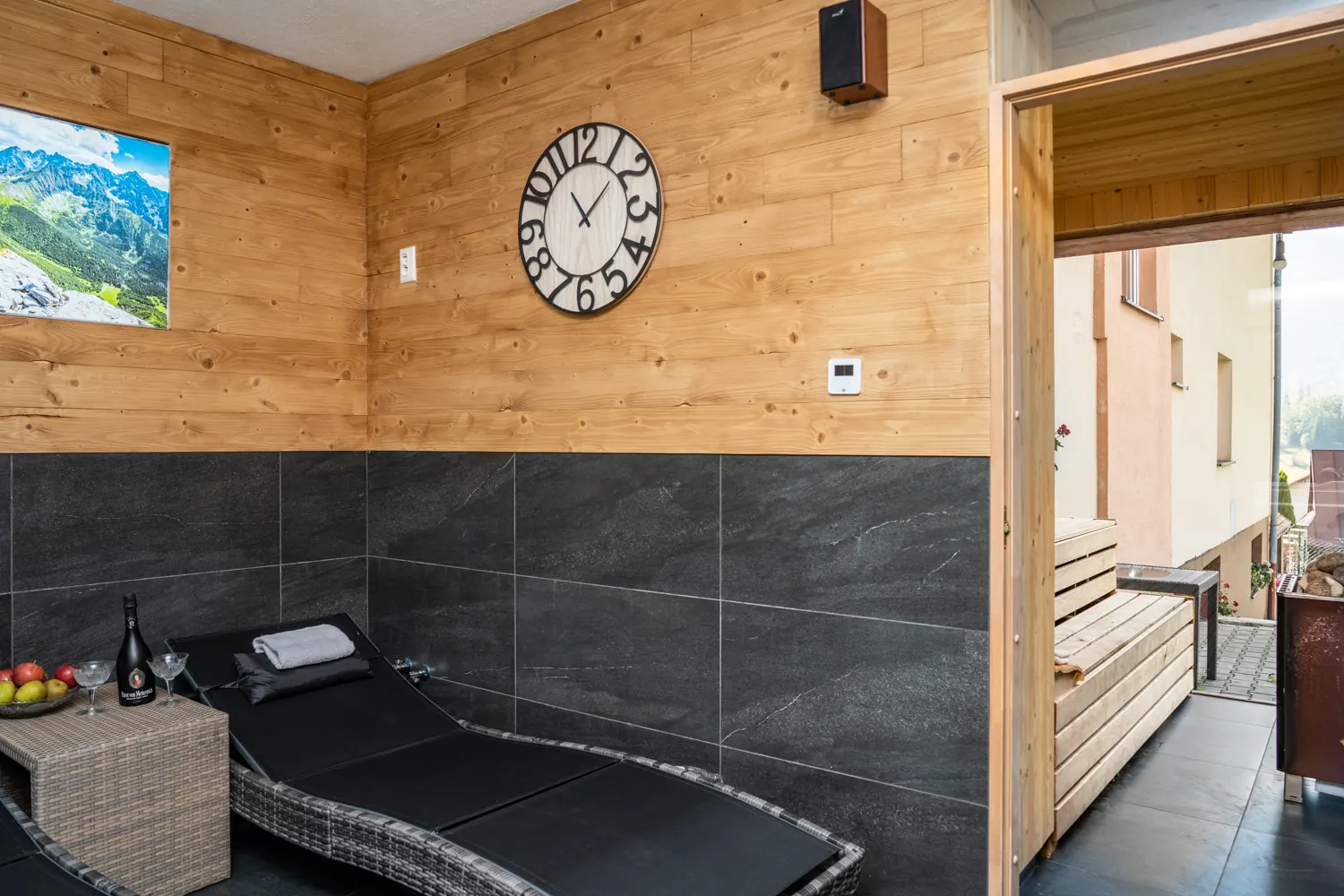 Lounger in the relaxation room, wall clock and door to the sauna