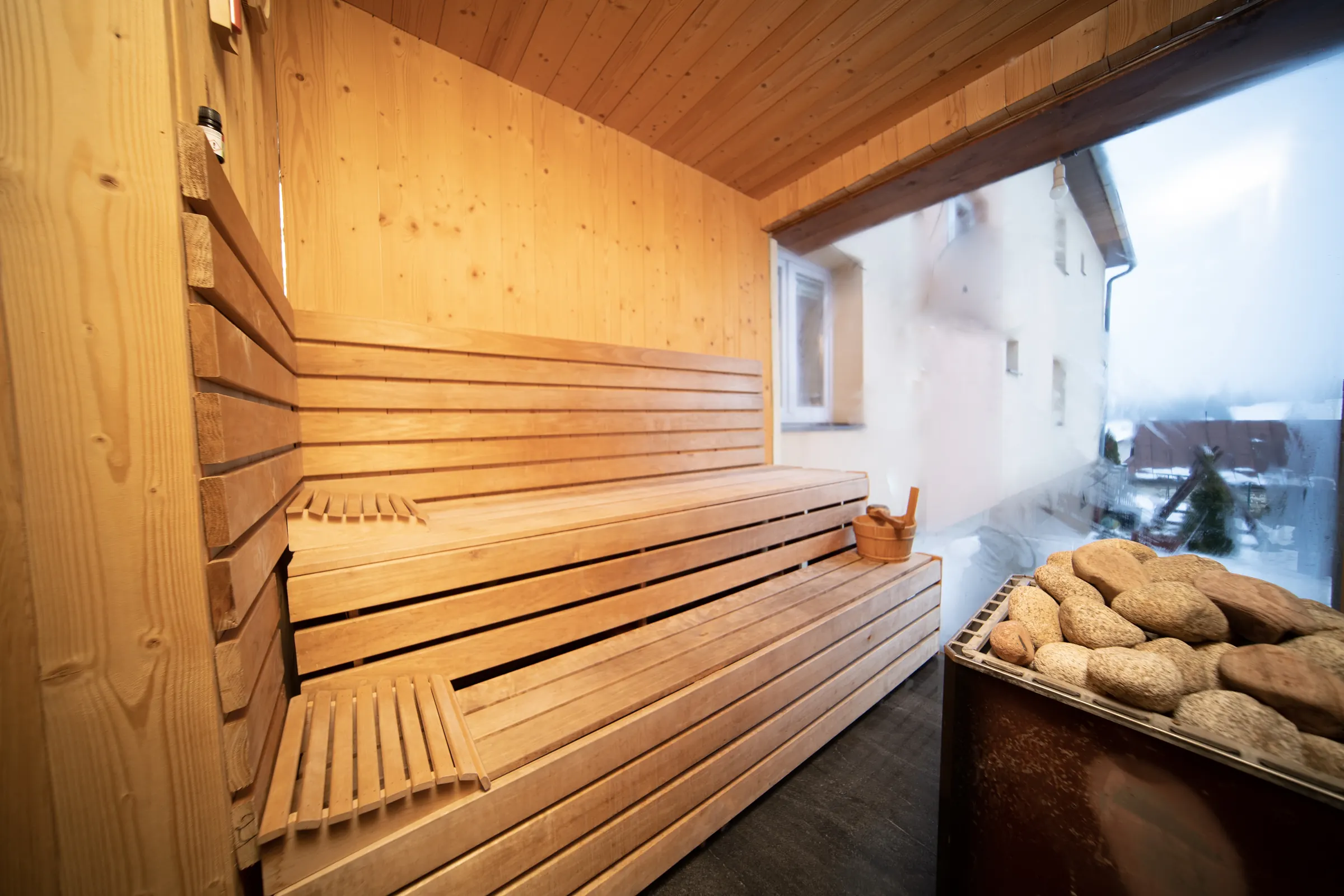 Sauna in winter: wooden benches, a bucket and a misted-up window